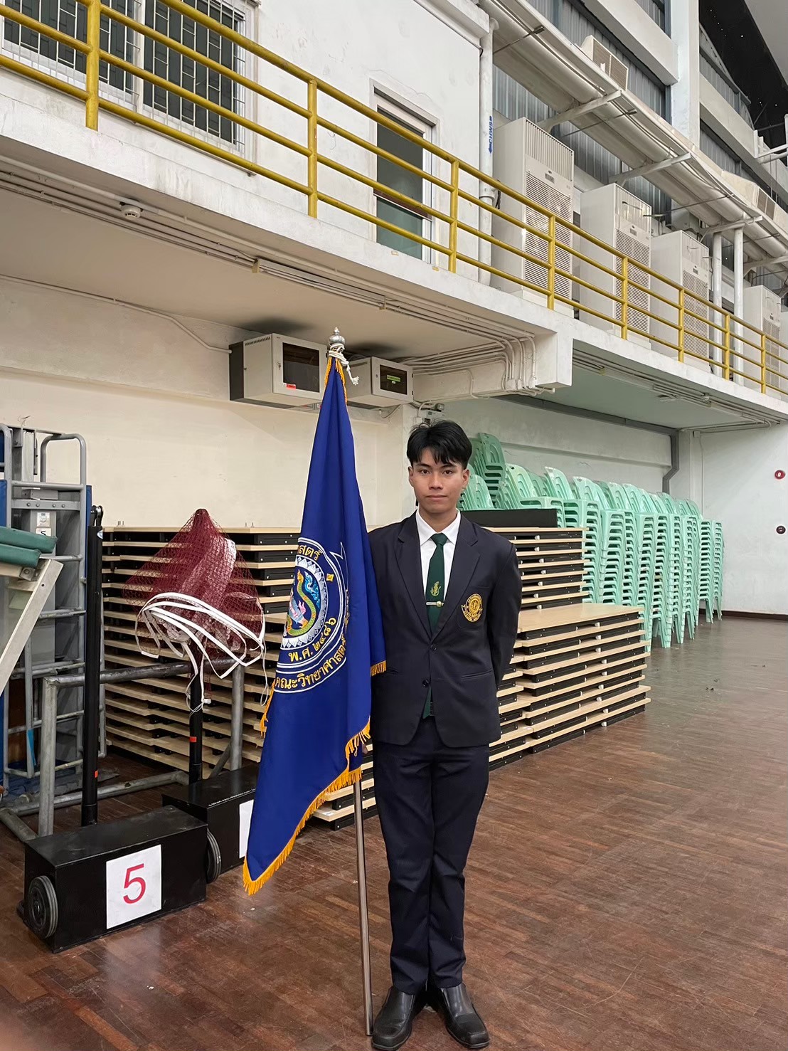 Panyarat carrying faculty flag at official ceremony
